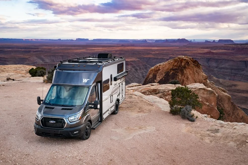 Winnebago EKKO RV parked on a red-rock canyon rim in the Arizona desert at sunset